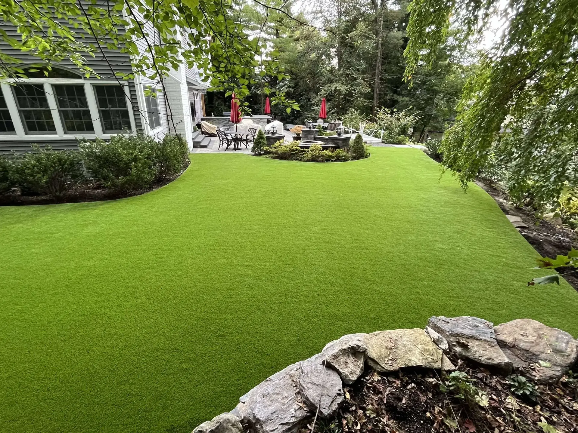 Completed synthetic lawn installation behind a Long Island home